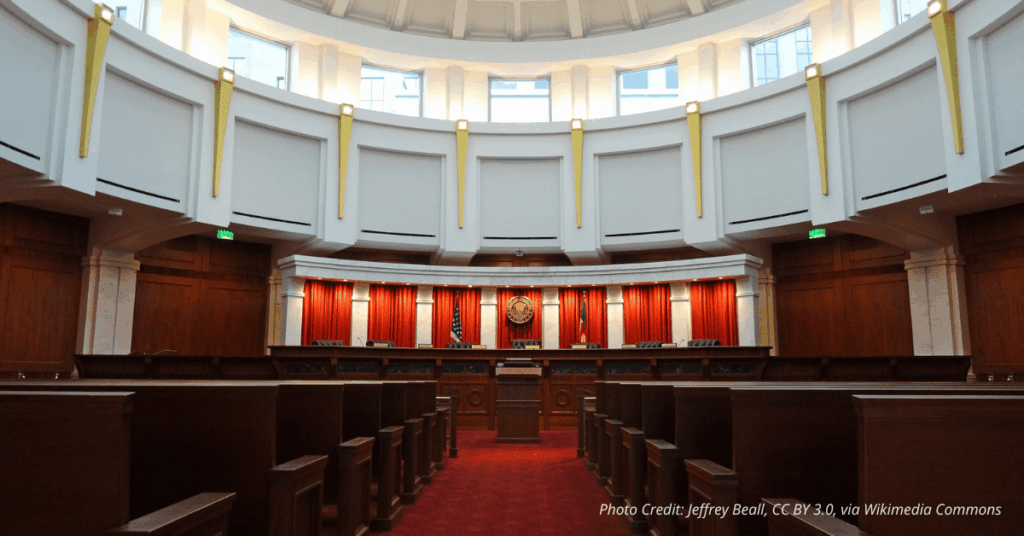 Colorado Supreme Court courtroom chamber with judicial bench and state seal, symbolizing state-level judicial authority