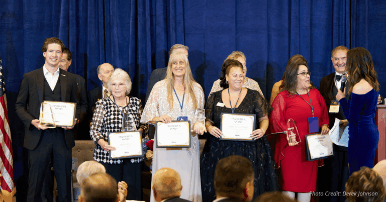 Trailblazer Award winners honored at RMV Gala, holding certificates and trophies onstage with Heidi Ganahl