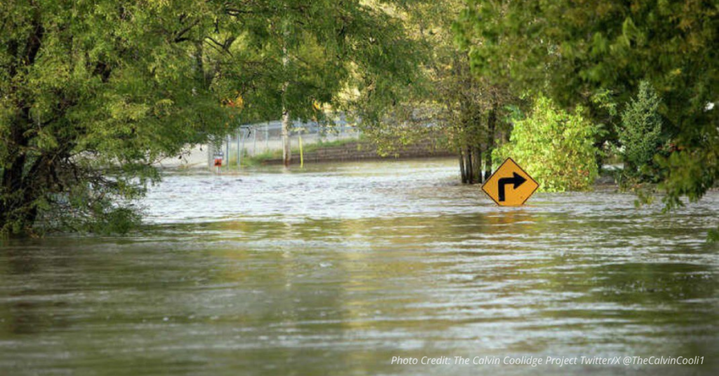 Flooded Texas roadway with submerged road sign after Hill Country storm