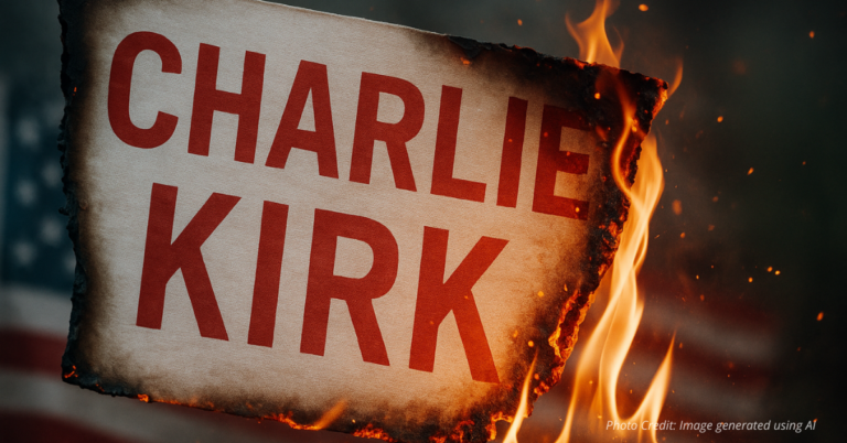 Tribute banner to Charlie Kirk with embers glowing after fire