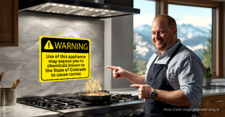 Jared Polis pointing to oversized gas stove warning label
