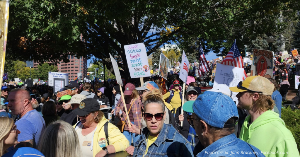 Protesters hold ‘No Kings’ signs in downtown Denver.