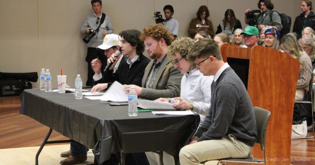 CMU student moderators seated at a table during a gubernatorial forum in Grand Junction.