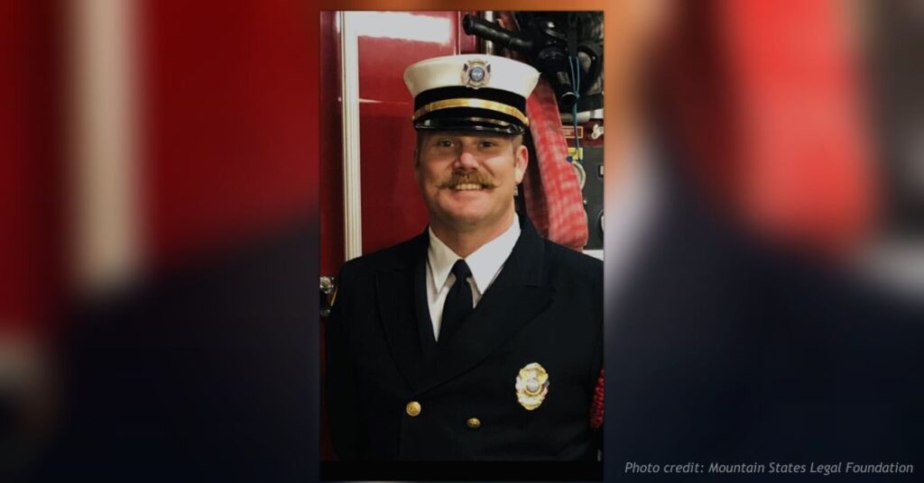 Former Florissant Fire Protection District Fire Chief Erik Holt in uniform standing inside a fire station.