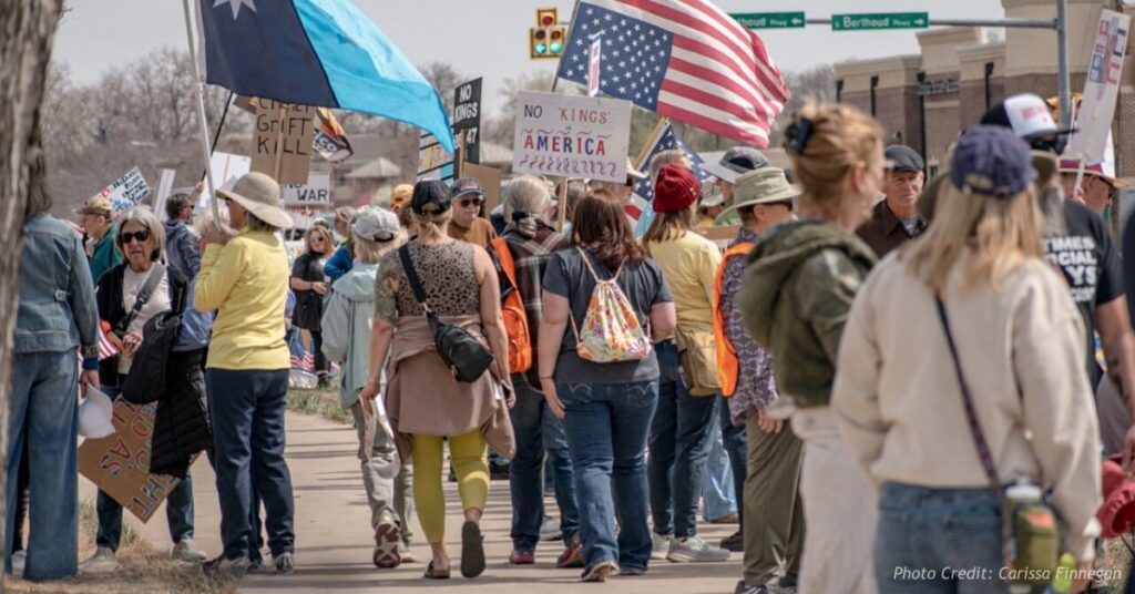 Protesters gather with signs and American flags during a No Kings demonstration in Berthoud, Colorado.