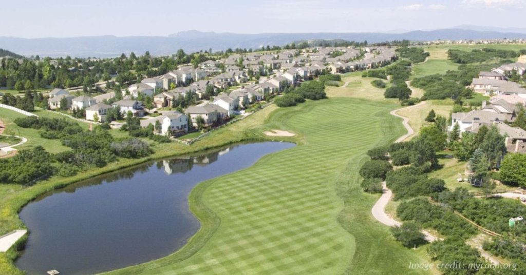 Aerial view of The Ridge at Castle Pines with homes, golf course and Colorado foothills.
